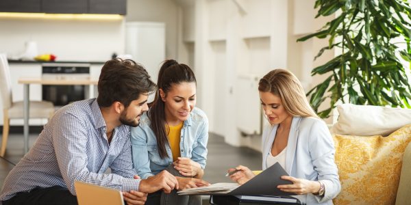 Female Real Estate agent offer home ownership and life insurance to young couple.